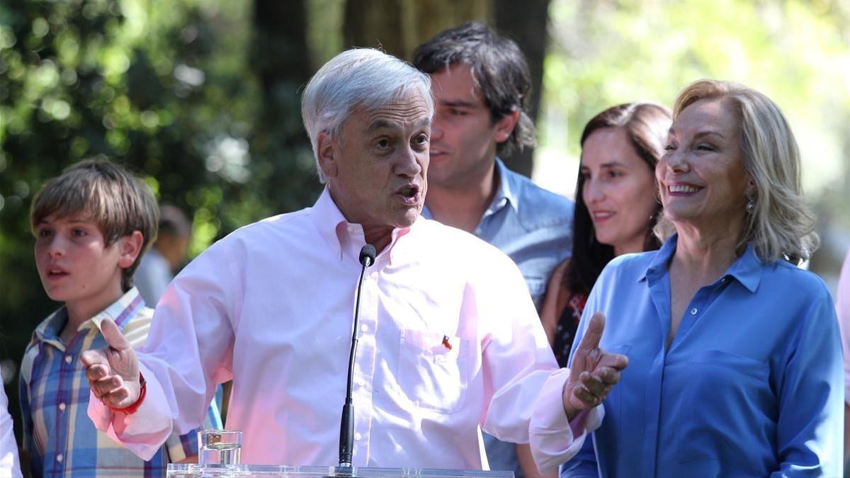 Piñera, junto a su nieto y su mujer, Cecilia Morel, se dirige a la prensa tras votar en un colegio público, en Santiago, el 17 de diciembre.