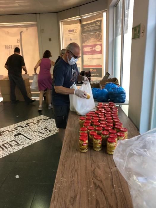 Preparativos y reparto de raciones para cocinar arroz al horno por el voluntariado de "Coronavirus amb Cor" de Alaquàs.