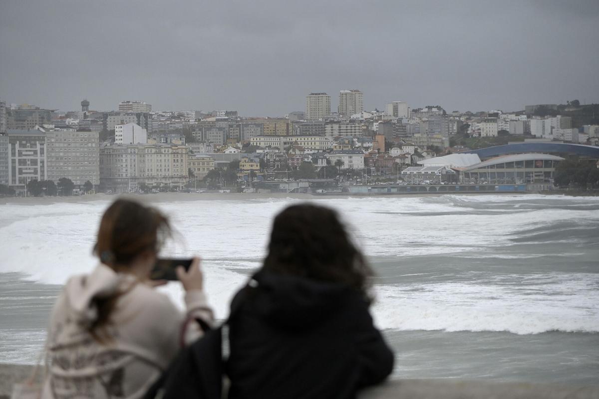 A Coruña. Temporal de viento y lluvia Dos personas fotografían el mar desde el pase. Marítimo. 20/10/2023 Foto: M. Dylan / Europa Press