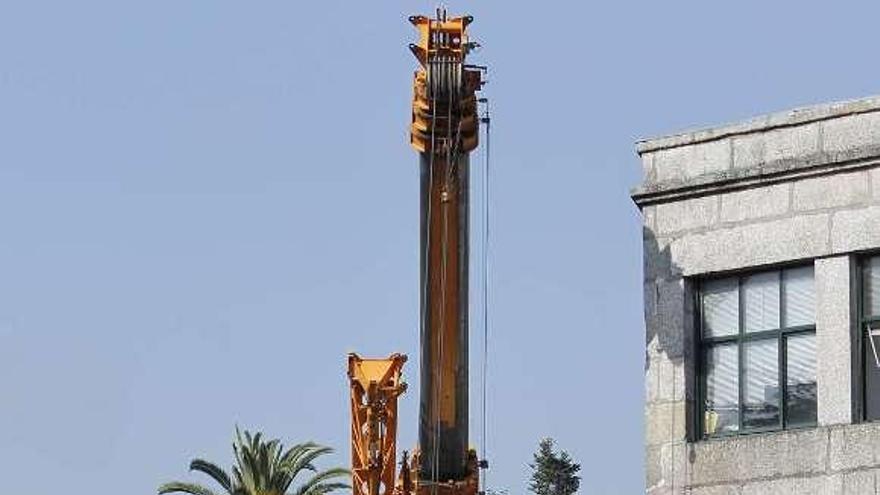 Una grúa intenta retirar el camión volcado. / r. grobas