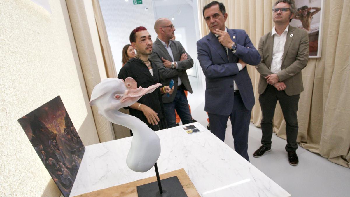 Uno de los artistas implicados en la exposición explica su trabajo al alcalde José Antonio Serrano.