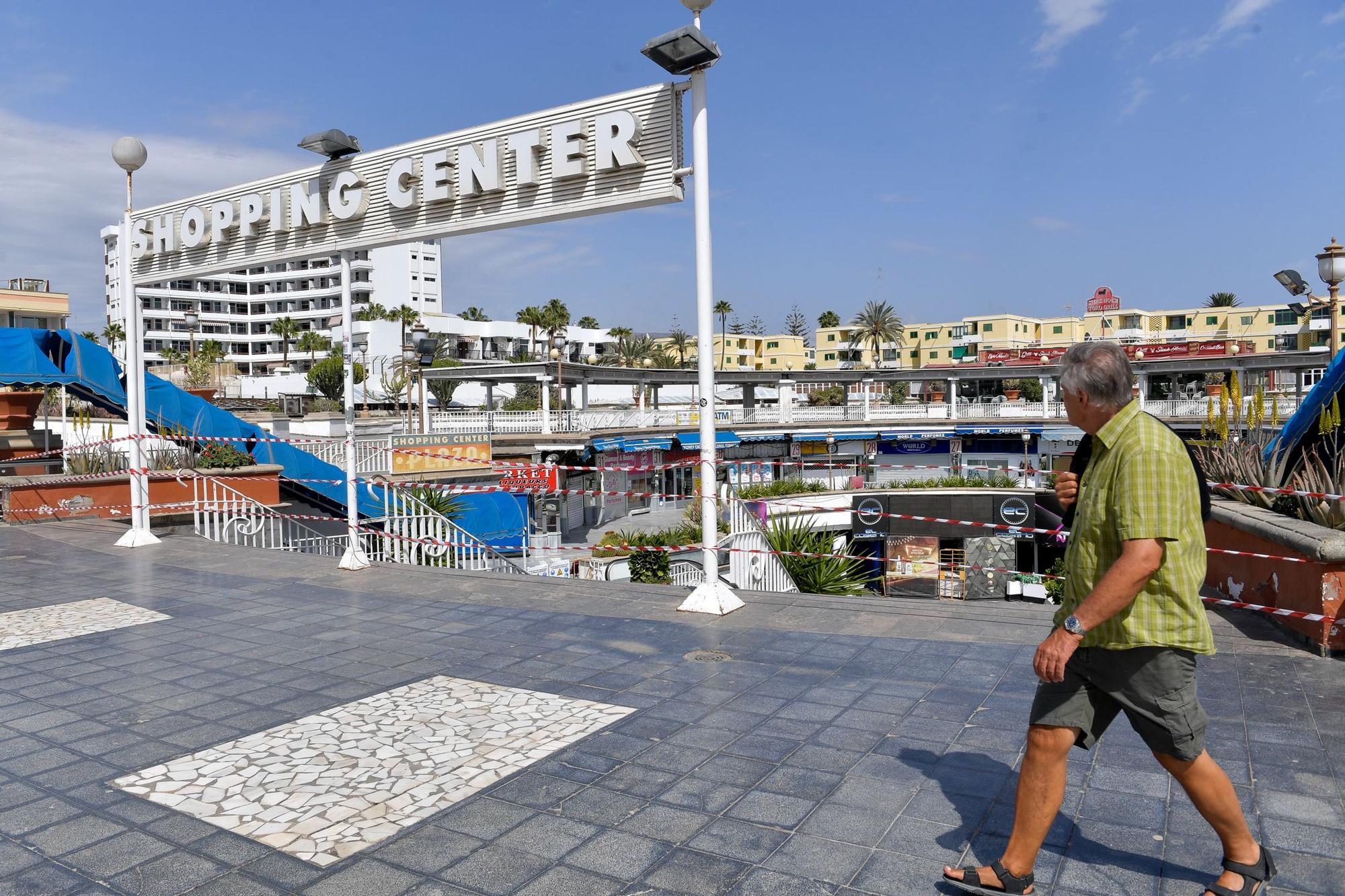 Un turista paseo frente a la entrada del centro comercial, precintada.