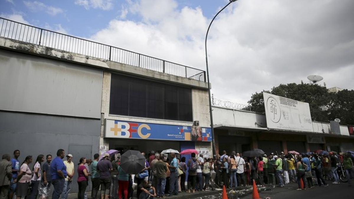 Citizens line up to buy chicken at a store in Caracas