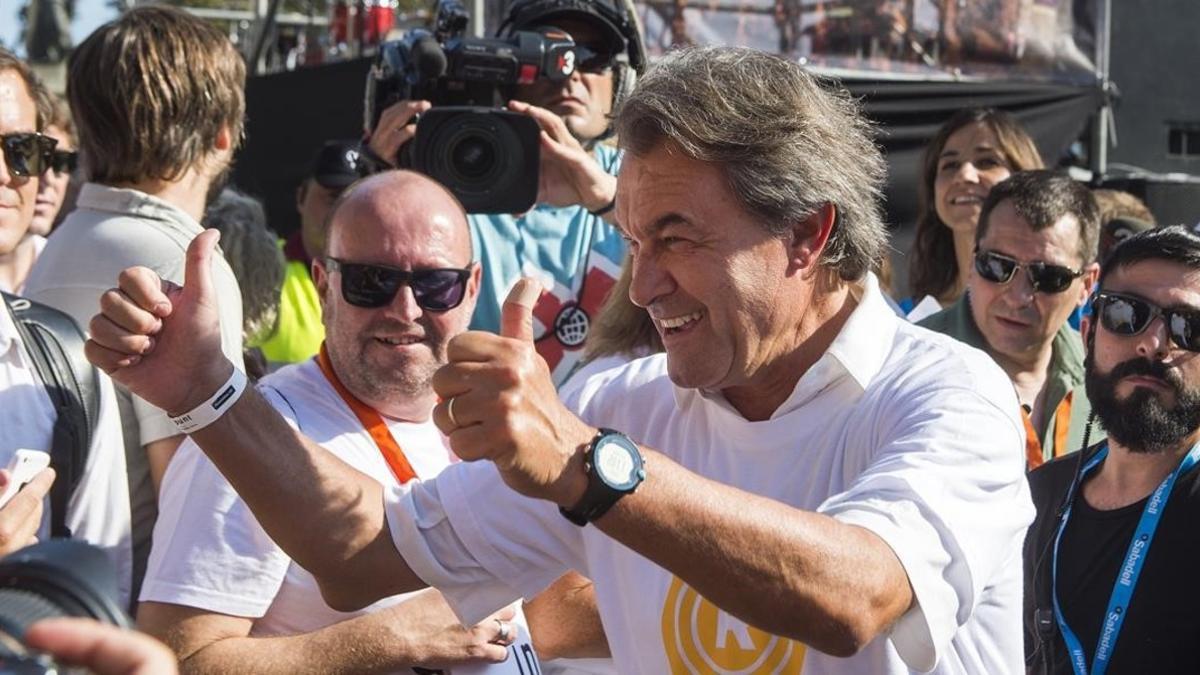 Artur Mas levanta los pulgares, en primera fila, en la manifestación del pasado 11 de septiembre en Barcelona.