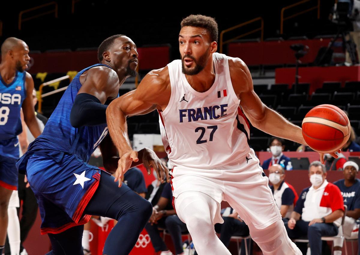 El francés Rudy Gobert trata de irse de Adebayo.