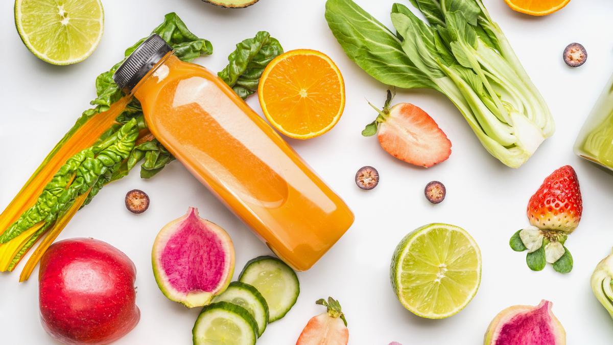Yellow smoothie bottle and Various healthy fruits and vegetables for clean eating and diet nutrition on white. Vegetarian food background frame. Vitamin content of fruit and vegetables