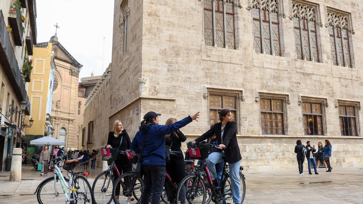 Un grupo de turistas visita el centro de València en biciletas de alquiler