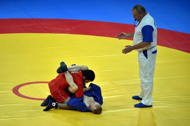 Aghasif Samadov (rojo) de Azerbaiyán compite contra Gintaras Katkus de Lituania en el sambo masculino en peleas de cuartos de final de 52 kg en los Juegos Europeos de 2019 en Minsk el 23 de junio de 2019.