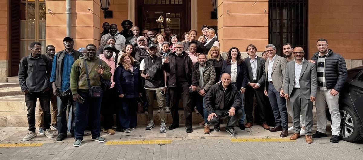 Personas migrantes, frente al Parlament junto a miembros del PSIB. | PSIB