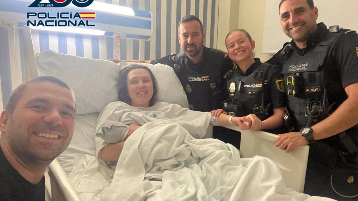 Los policías nacionales posan con la pareja y el bebé