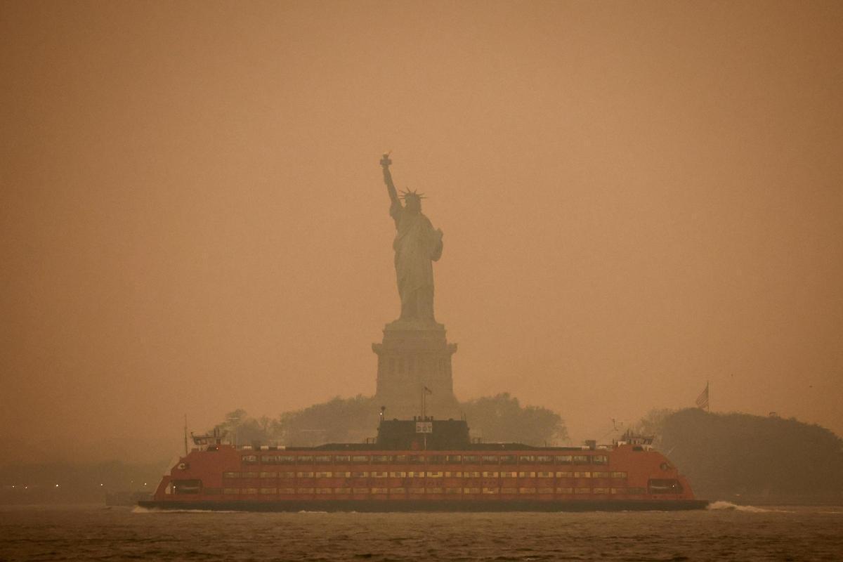 L'Estàtua de la Llibertat, coberta de boira i fum causat pels incendis forestals al Canadà.