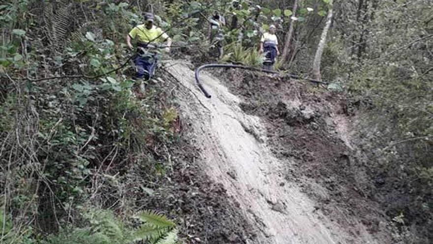 Operarios municipales trabajan limpiando la zona en la que se rompió la tubería de Llerandi, ayer.