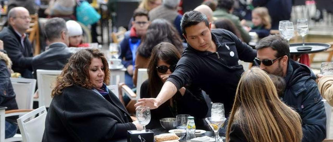Un camarero atiende a clientes en una plaza de Pontevedra. // Gustavo Santos