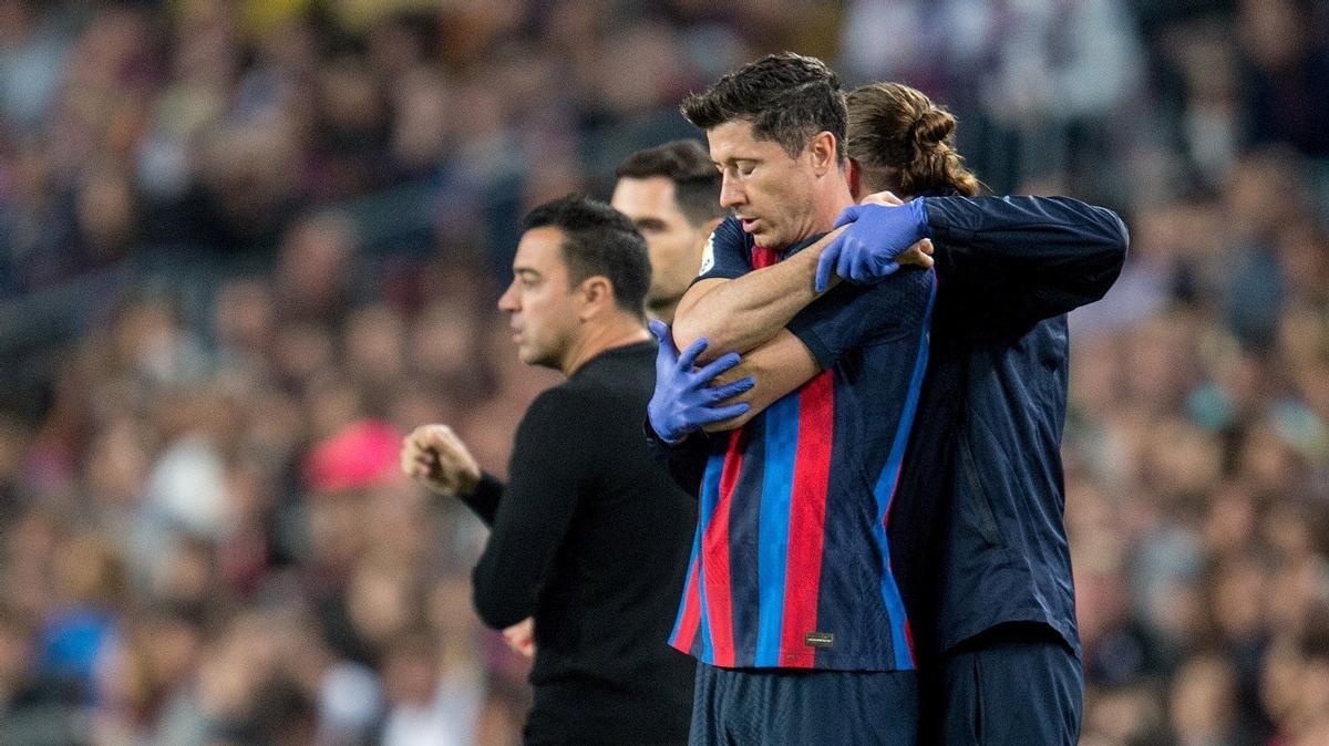 Lewandowski es tratado de sus problemas en la espalda por un fisio del Barça durante el encuentro con el Girona en el Camp Nou.