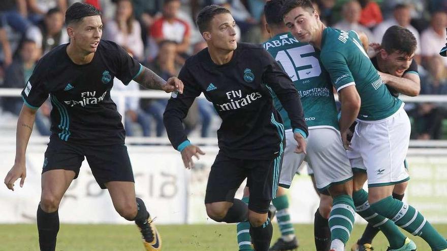 Jugadores del Coruxo y del Castilla forcejean en un saque de esquina en un lance de la primera vuelta. // Ricardo Grobas