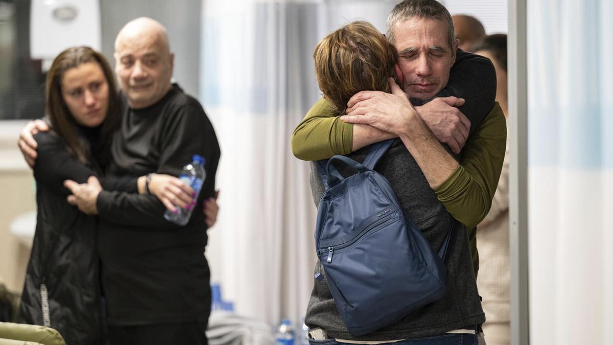 Luis Har (izquierda) y Simón Marmán abrazan a familiares en el Hospital Seba en el que ingresaron tras ser liberados, este lunes.