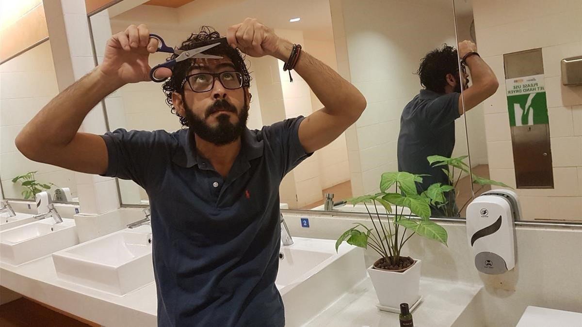 Hassan al Kontar se corta el pelo en los servicios del aeropuerto de Kuala Lumpur, el pasado 21 de agosto.