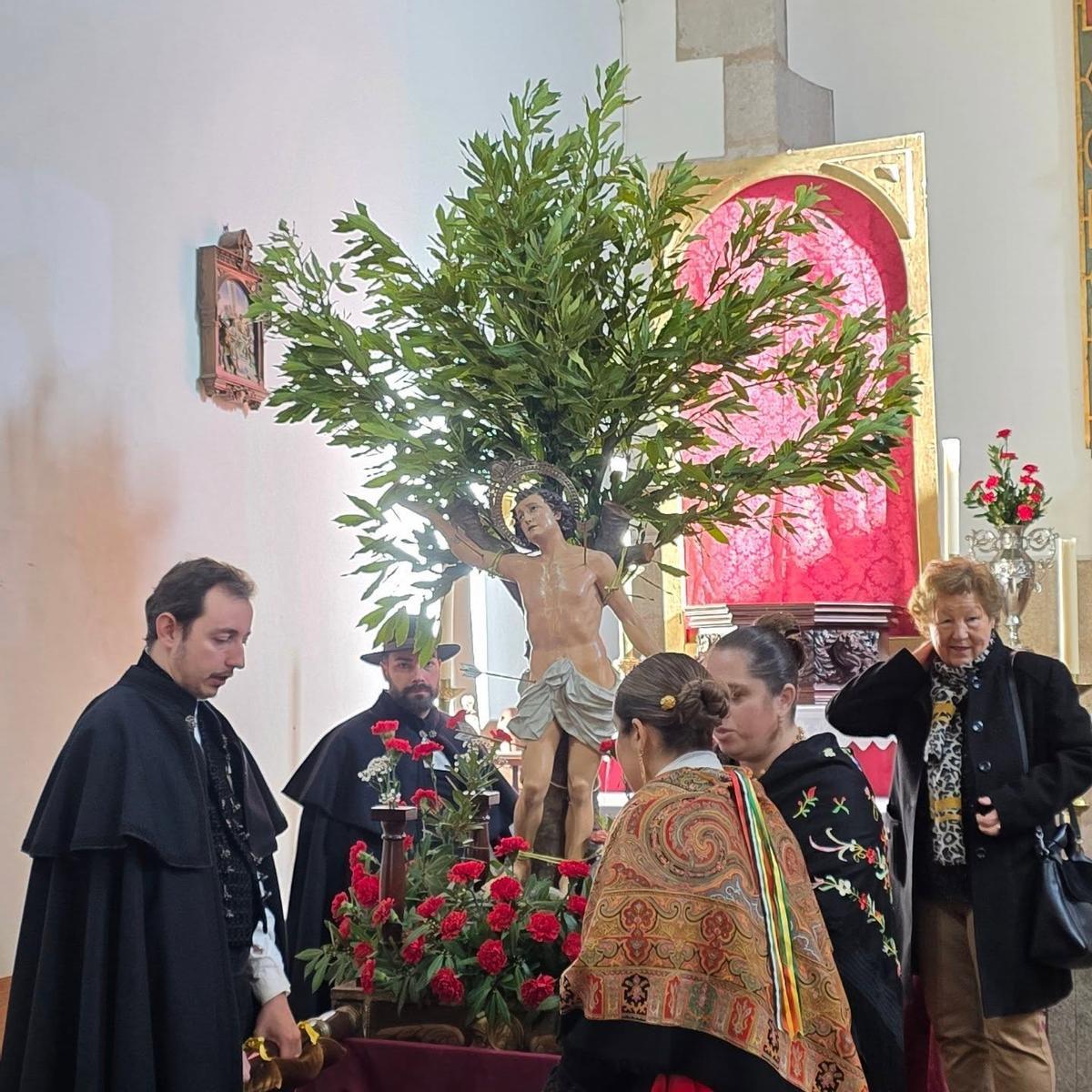 Devotos con la imagen de San Sebastián, antes de salir en procesión por las calles de Coria.