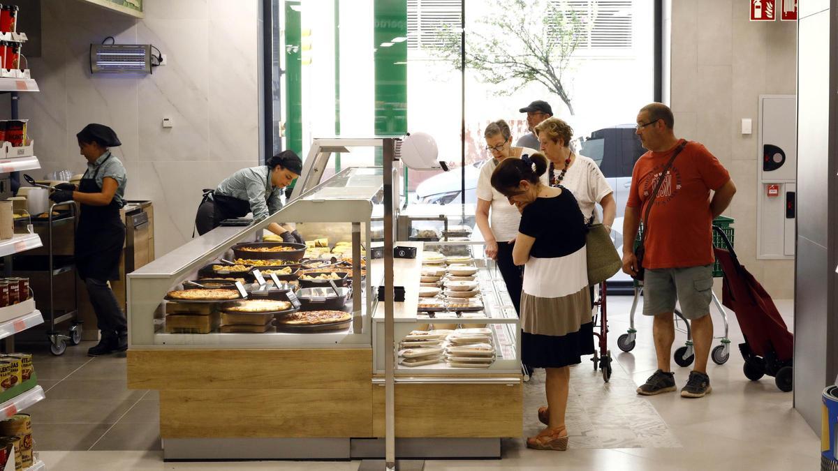 Varios clientes observan los platos de comida ya preparada en un establecimiento de Mercadona, en Zaragoza.