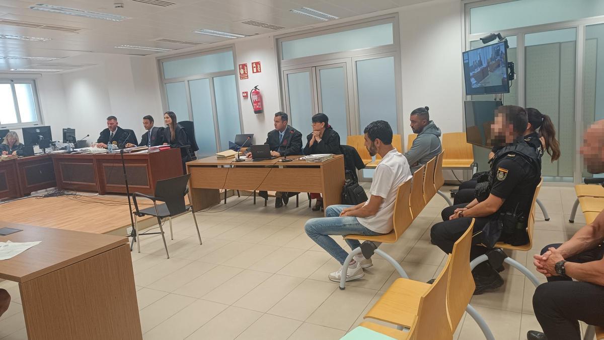 Los dos acusados sentados en el banquillo al inicio del juicio, el lunes.