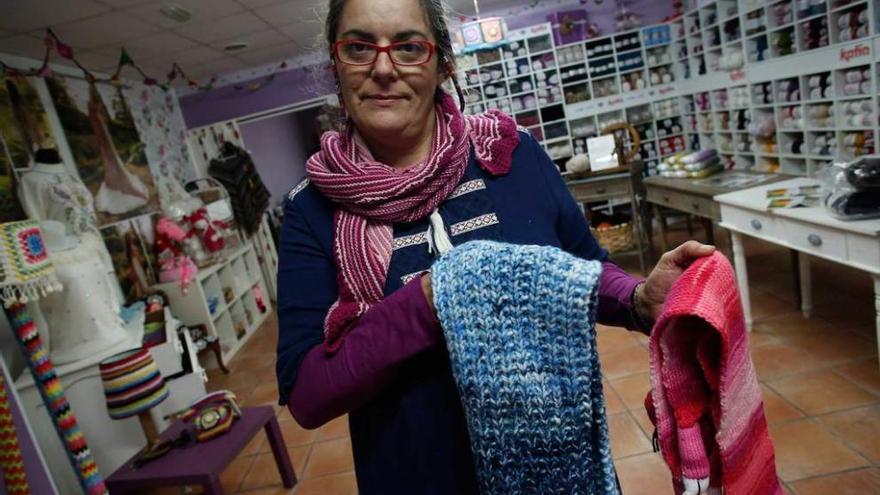 Pilar Menéndez muestra unas bufandas como las que anima a tejer con fines solidarios.