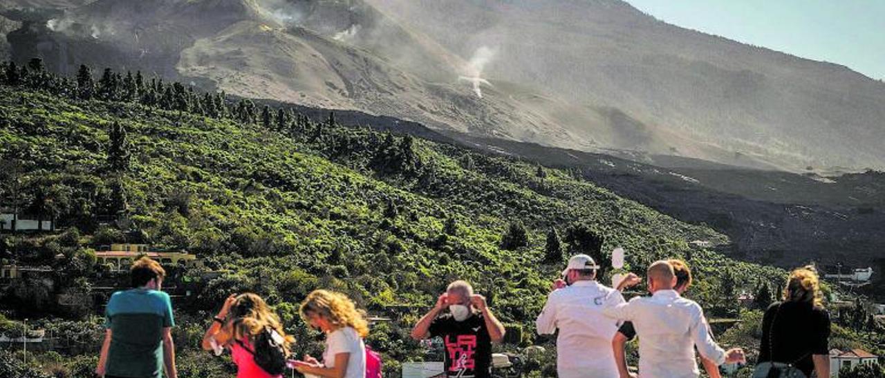 Un grupo de personas observa el volcán de Tajogaite desde la plaza de Tajuya. | | ANDRÉS GUTIÉRREZ