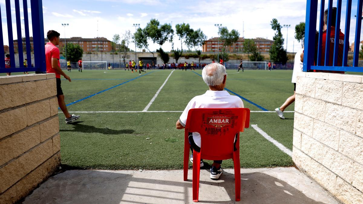 Un espectador presencia un encuentro de fútbol base en Aragón.