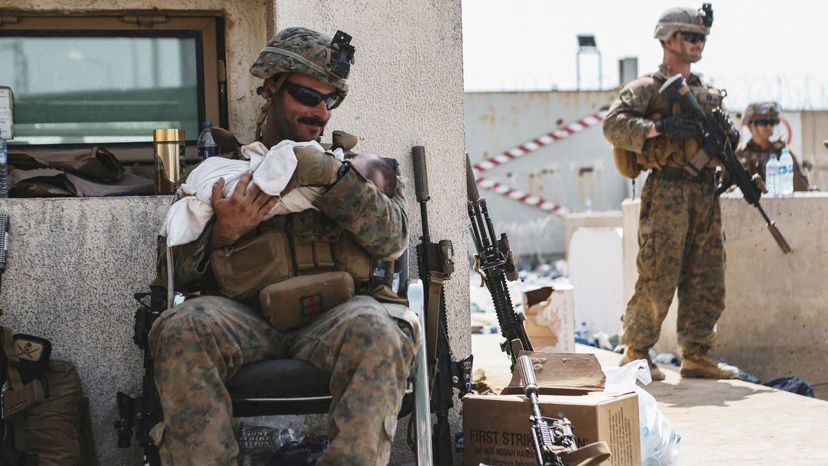 Un soldado de EEUU sostiene a un bebé en el aeropuerto de Kabul.