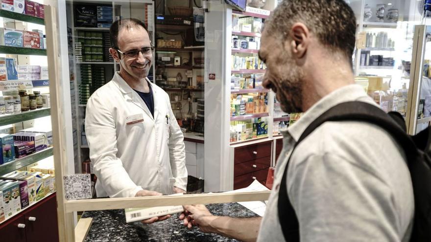 David Nogueras, de la farmàcia Nogueras, atenent a un client que compra un test d’antígens | OSCAR BAYONA