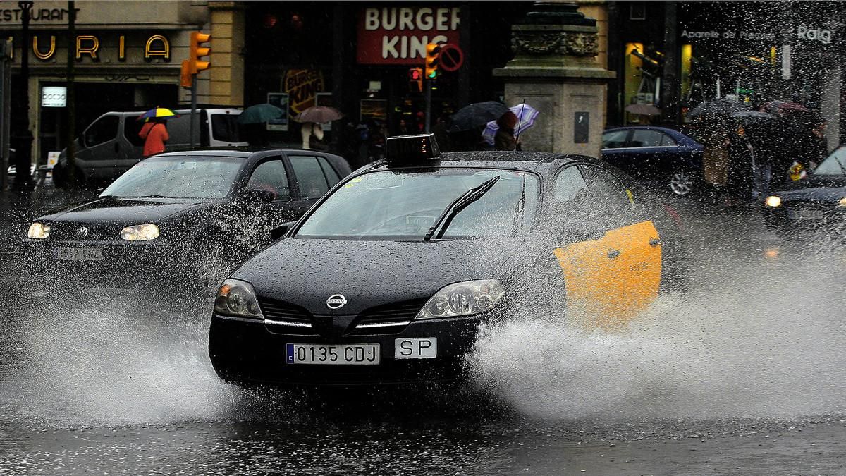 Coches con lluvia en la plaza de Catalunya de Barcelona.