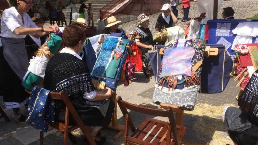 Un grupo de encajeras de bolillos, trabajando ante la mirada de los asistentes.