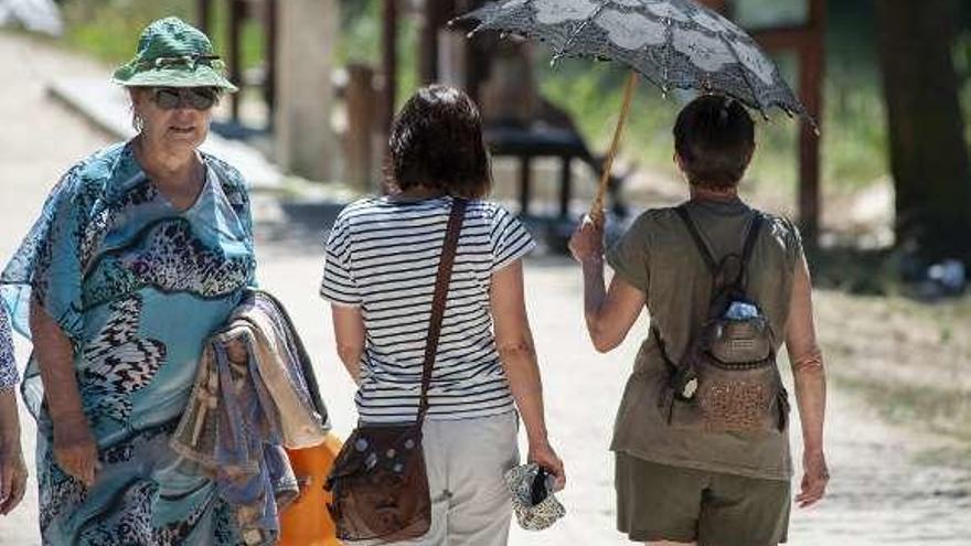 Dos mujeres se protegen del sol con una sombrilla. // Fotografías: Brais Lorenzo