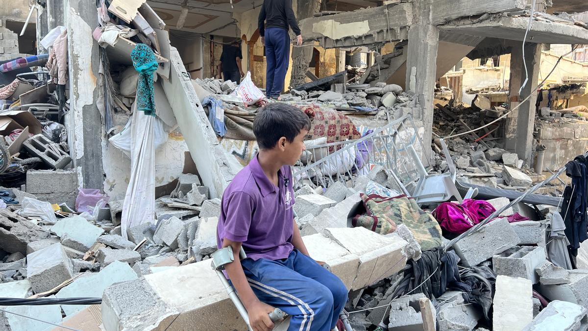 Palestinos sobre los escombros de un edificio en Gaza destruido por las bombas de Israel.