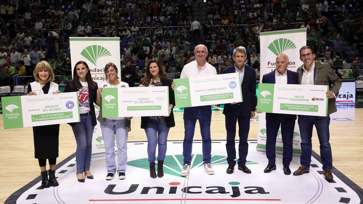 Fundación Unicaja entrega los cuatro cheques solidarios en el descanso del Unicaja-Barça.