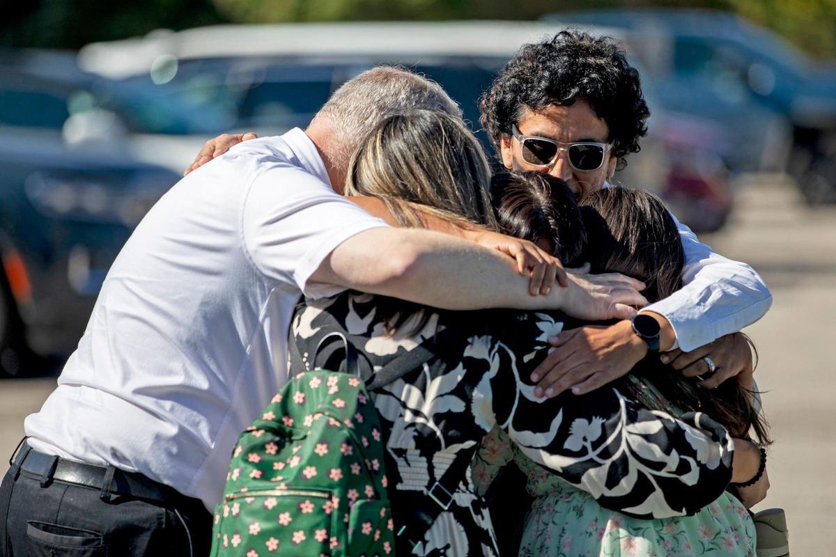 Una familia se abraza emocionada frente a la iglesia atacada el domingo en Grand Blanc, Míchigan (EEUU).