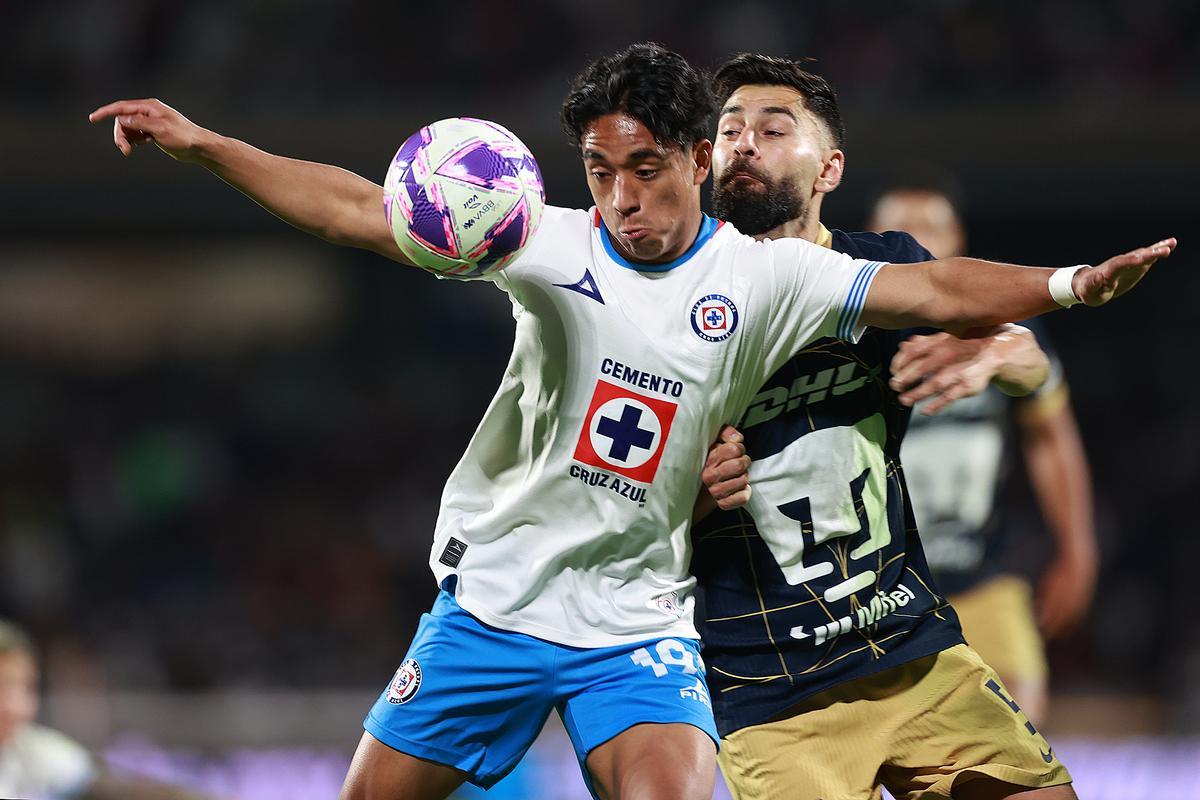 Amaury Morales de Cruz Azul (derecha) disputa el balón con Rubén Duarte durante un partido frente a Pumas del torneo Apertura 2024 de la Liga de México