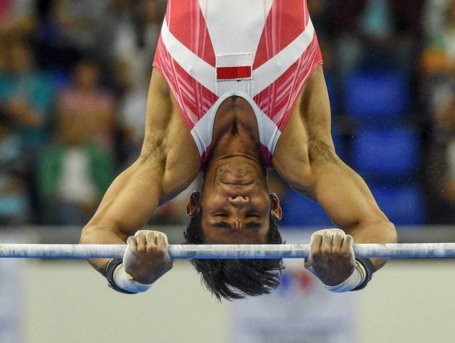 Dwi Samsul Arifin de Indonesia compite en el evento de barra horizontal artística de gimnasia masculina en los Juegos SEA (Juegos del Sudeste Asiático) en Manila.