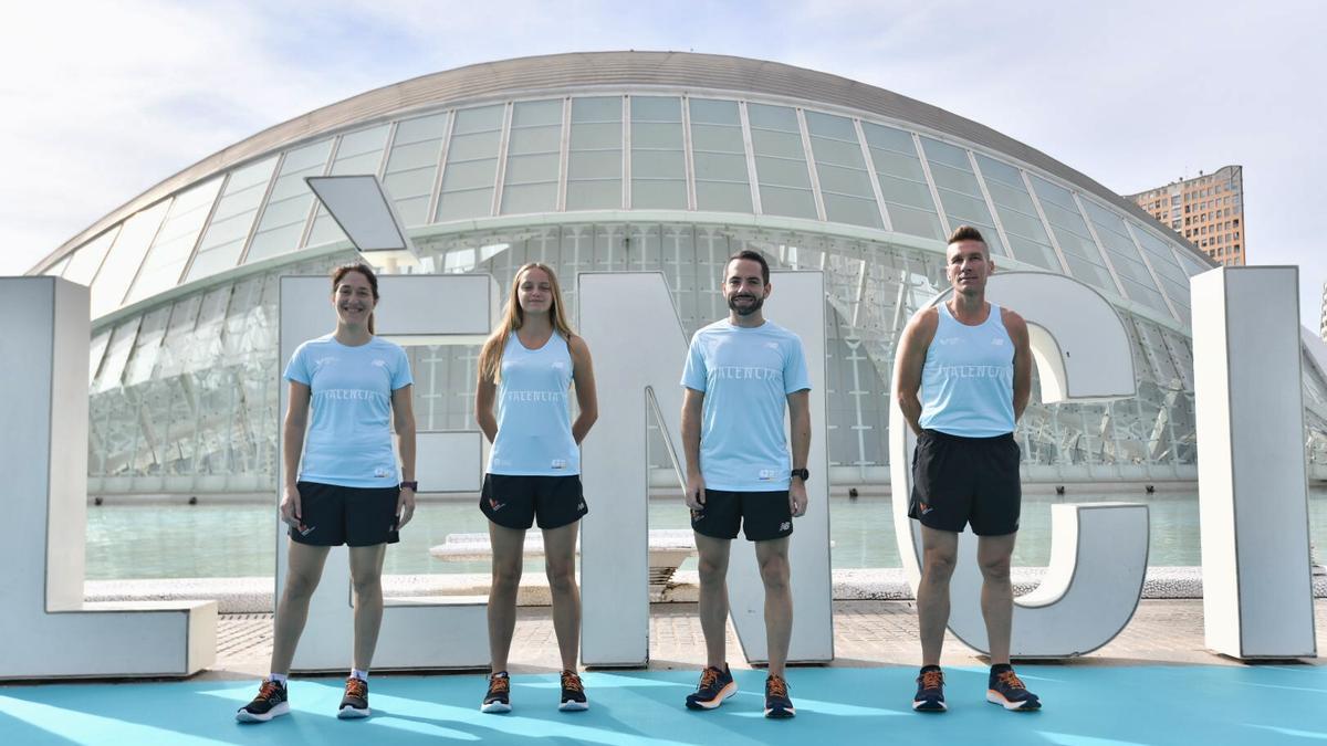 Cuatro atletas populares posan con las camisetas del Maratón Valencia 2022