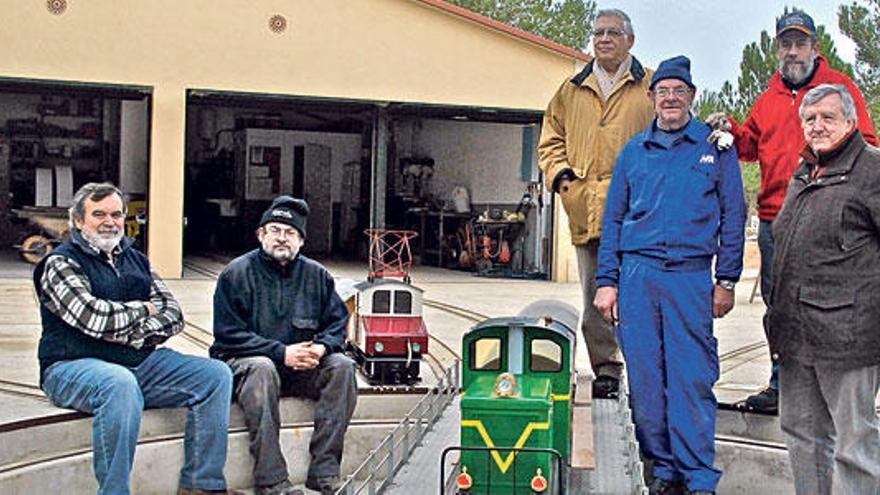 Miembros del Club Ferroviario Vaporista, junto a sus trenes y el taller en miniatura.