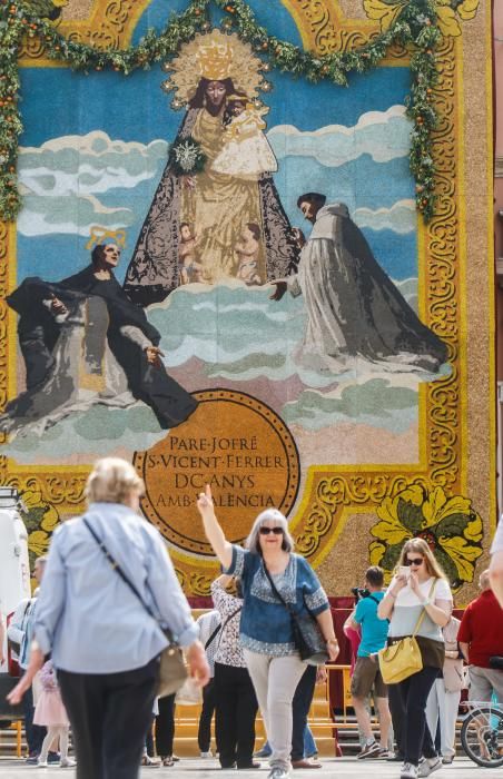 Numerosas personas acuden a la plaza de la Virgen de València para contemplar el tapiz floral