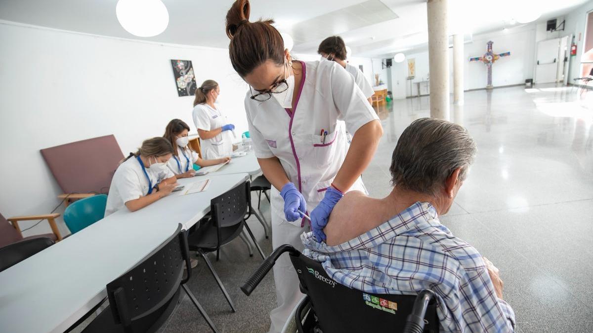 Una sanitaria inoculando a una persona con la vacuna contra la covid.