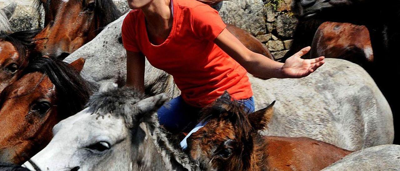 Una aloitadora se mueve por el curro sobre uno de los caballos de O Santo.