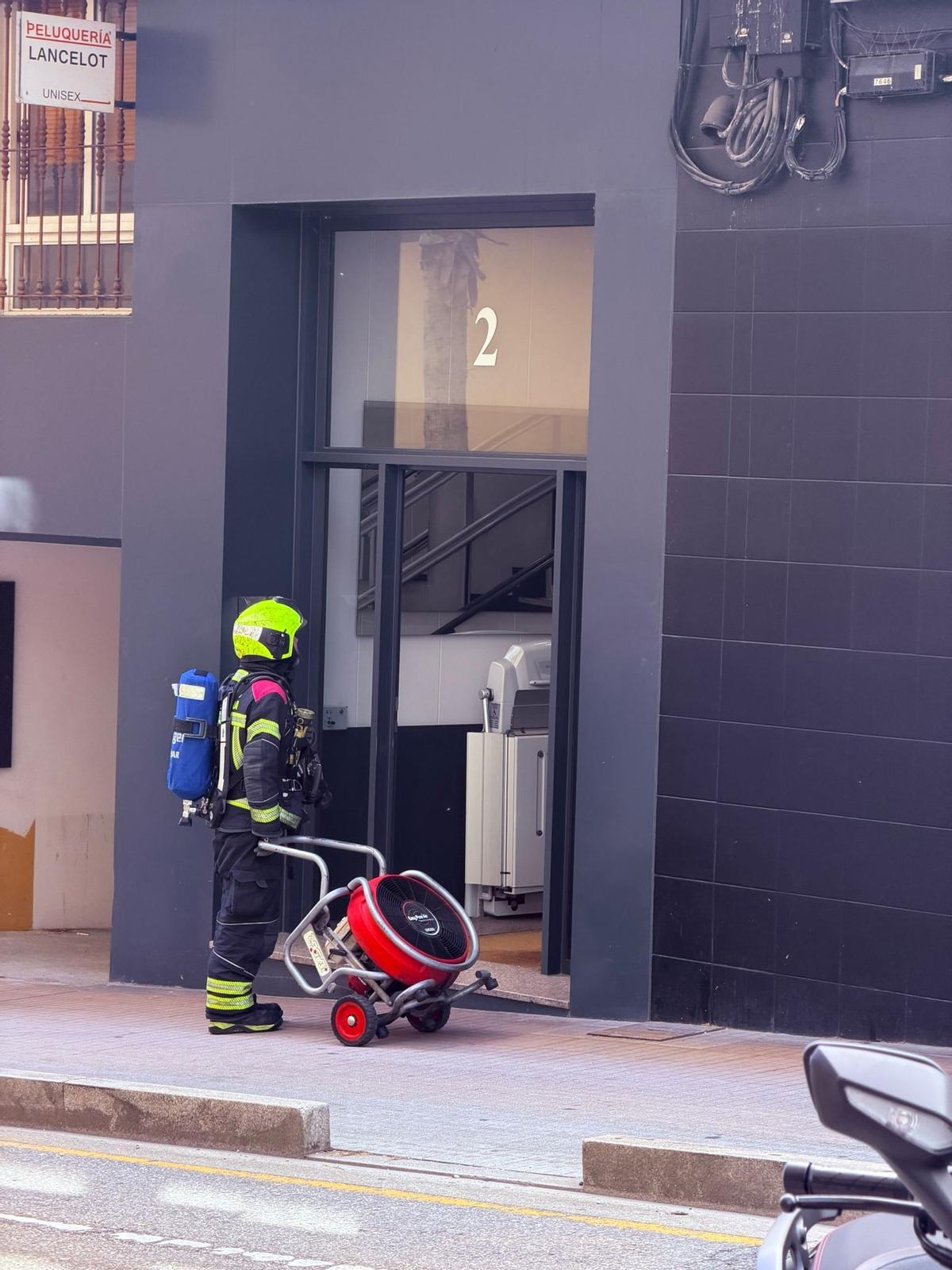 Un bombero, ante el portal del edificio donde ocurrió el incendio