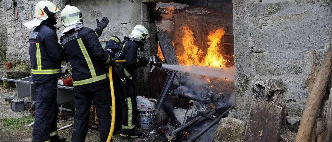 Labores de extinción del incendio que en 2015 arrasó una casa en Castro do Cabo. // Bernabé / Javier Lalín