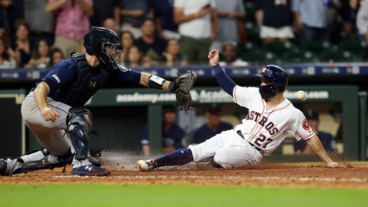 José Altuve, de los Houston Astros, llega al plato.