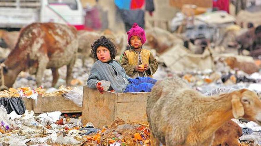 Niños entre la basura, junto a su casa, en Kabul, la capital afgana.