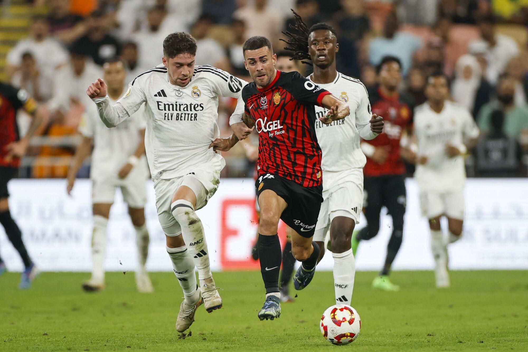 YEDA (ARABIA SAUDÍ), 09/01/2025.- Eduardo Camavinga (d) y Fede Valverde (i) del Real Madrid disputan un balón ante el centrocampista del Mallorca Dani Rodríguez (c) durante el partido de semifinales de la Supercopa de España de fútbol entre el Real Madrid y el Mallorca, este jueves en Yeda. EFE/ Alberto Estévez