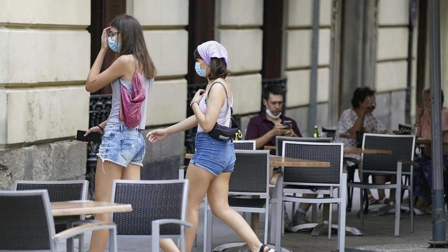 Personas con mascarilla en la calle y clientes en terrazas de Madrid antes de que entre en vigor este jueves la nueva ley que obligará a llevar la mascarilla y otras normas.