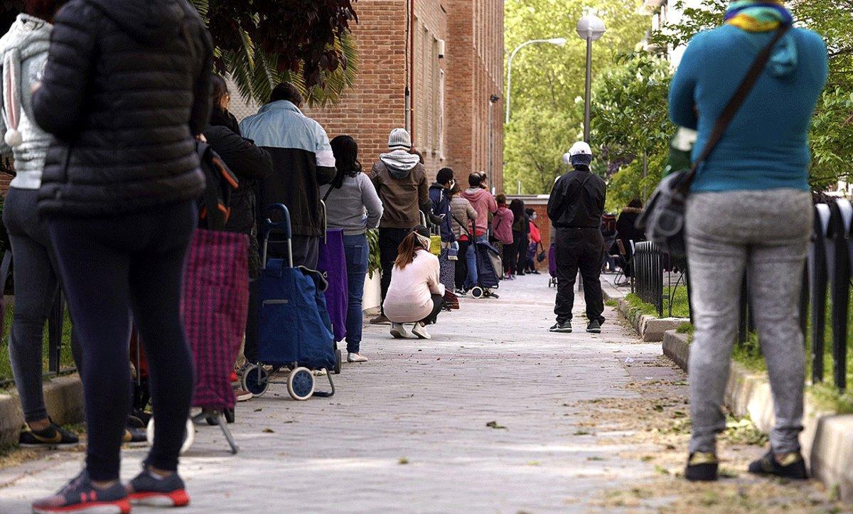 Personas esperan en la cola para recoger los alimentos que reparte la Fundación Madrina de Madrid, el pasado 28 de abril.