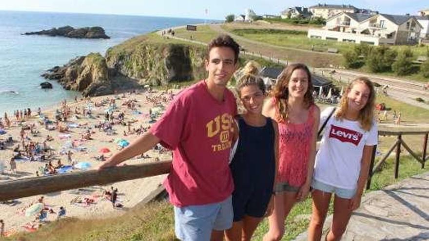 Los amigos ovetenses Daniel Álvarez, Ángela Ferrería, Elena Pérez y Elena Alonso, ayer, saliendo de la playa tapiega del Murallón, que estaba abarrotada de gente